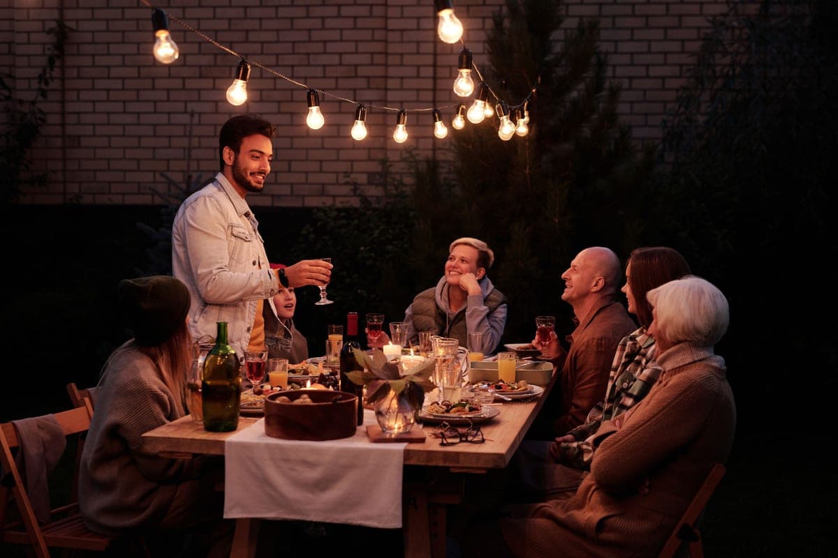 String lights over a backyard gathering in the evening