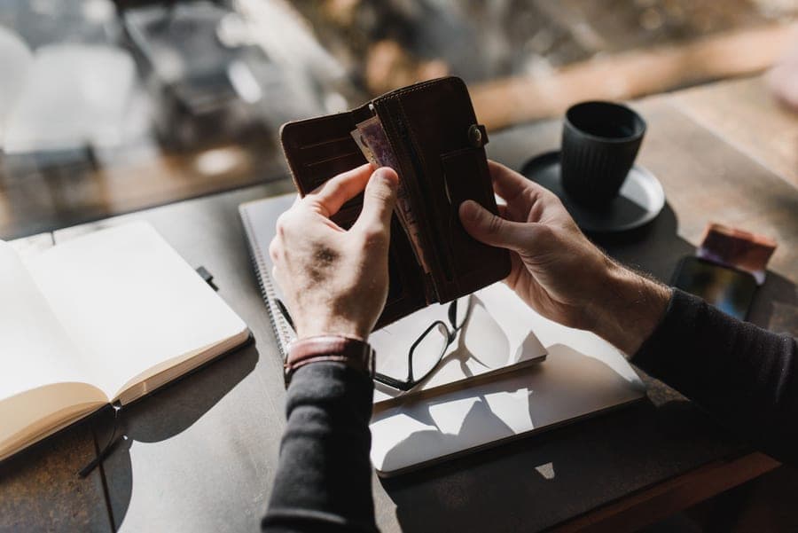 A wallet and notepad on a desk during budget planning